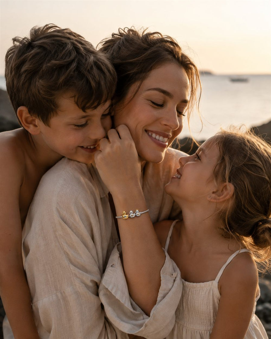 Madre con sus hijos al atardecer con pulsera de patitos